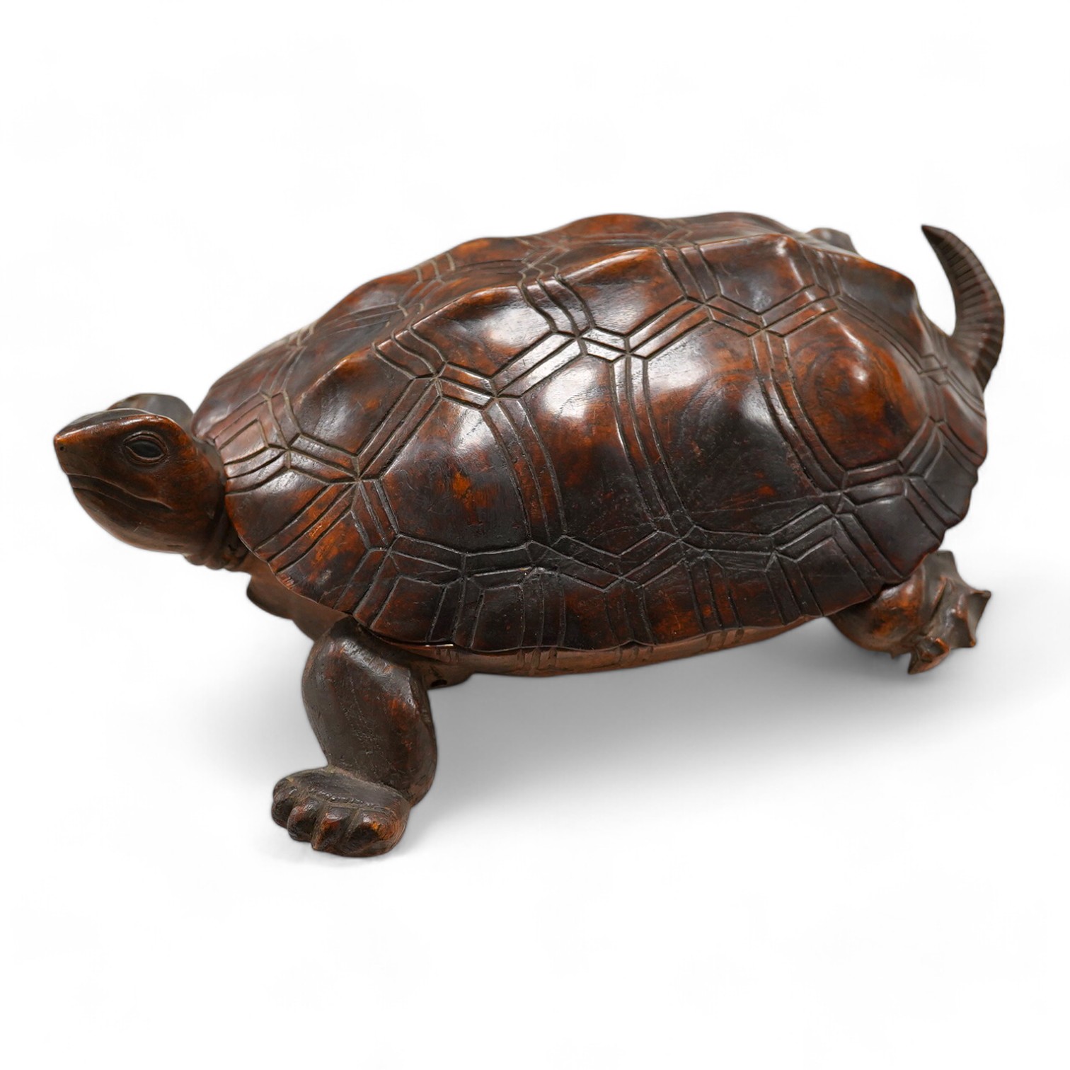 A late 19th century/early 20th century carved walnut box in the form of a tortoise, the shell opening to reveal a compartment, 29cm wide. Condition - fair, tail re-glued